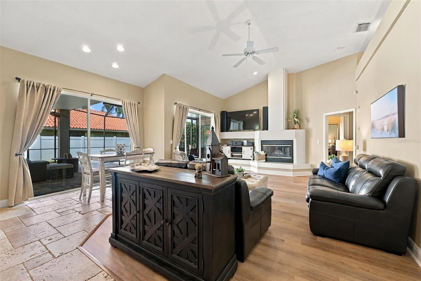 Family room with two sets of sliding glass doors to pool &amp; wood burning fireplace