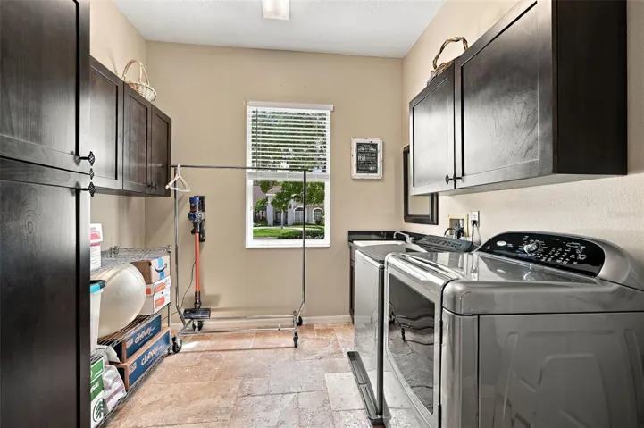 Primary Laundry with utility sink and storage cabinets