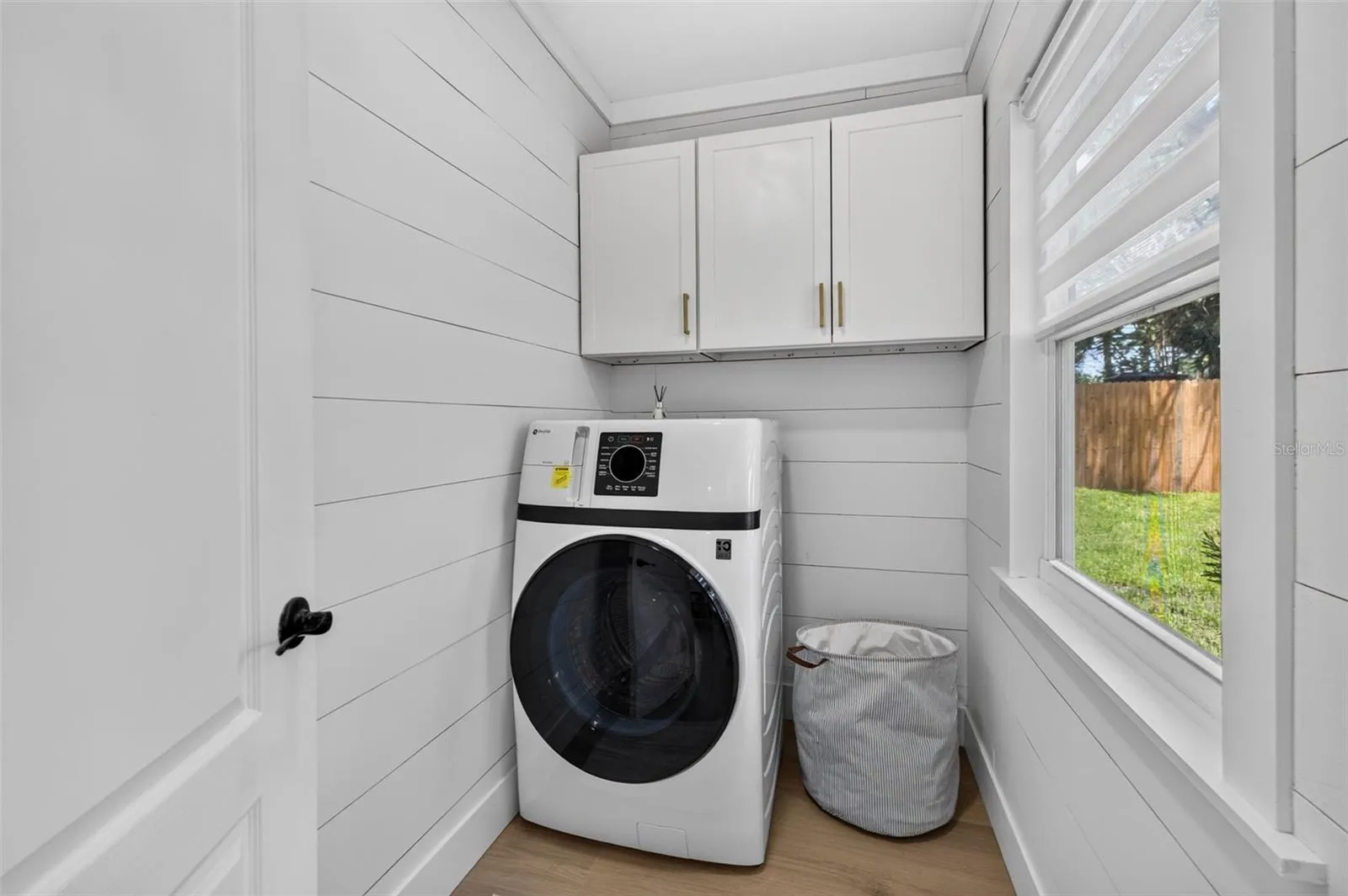 Seperate laundry room with high-end combined washer/dryer.