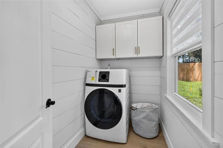 Seperate laundry room with high-end combined washer/dryer.