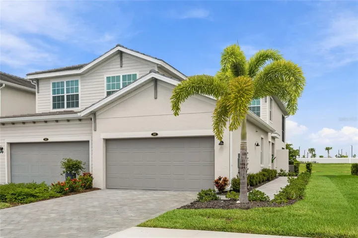Beautifully landscaped front exterior with lush greenery and a picturesque water view.