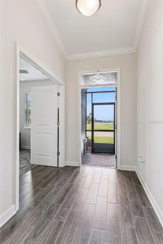 Foyer features a transom window, crown molding and views of the community boat ramp