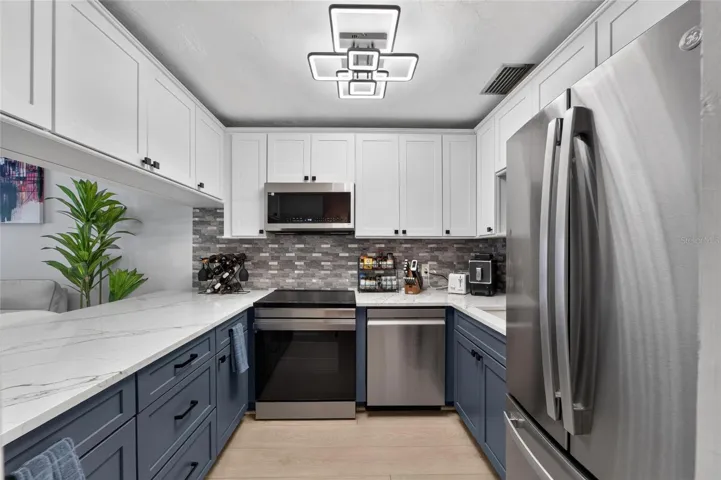 Completely reonovated kitchen with two-toned Shaker style cabinetes.