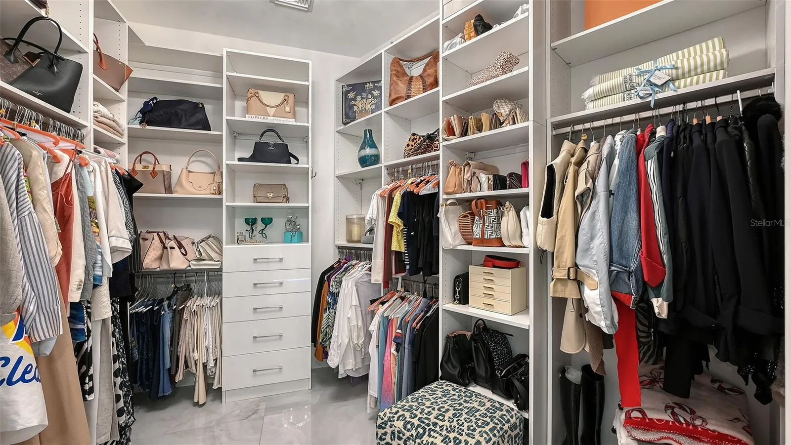 Custom-designed primary closet with elegant display areas and refined, organized storage.