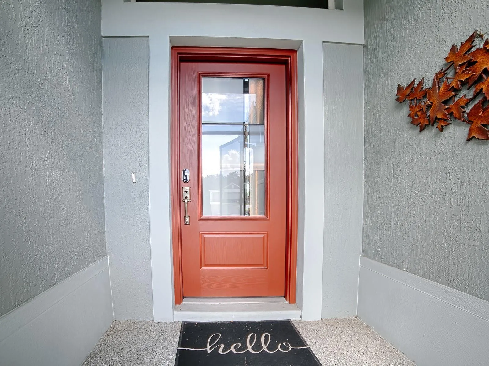 INVITING ENTRANCE WITH A DECORATIVE CONCRETE COATED ENTRANCE AND LEADED GLASS FRONT DOOR.