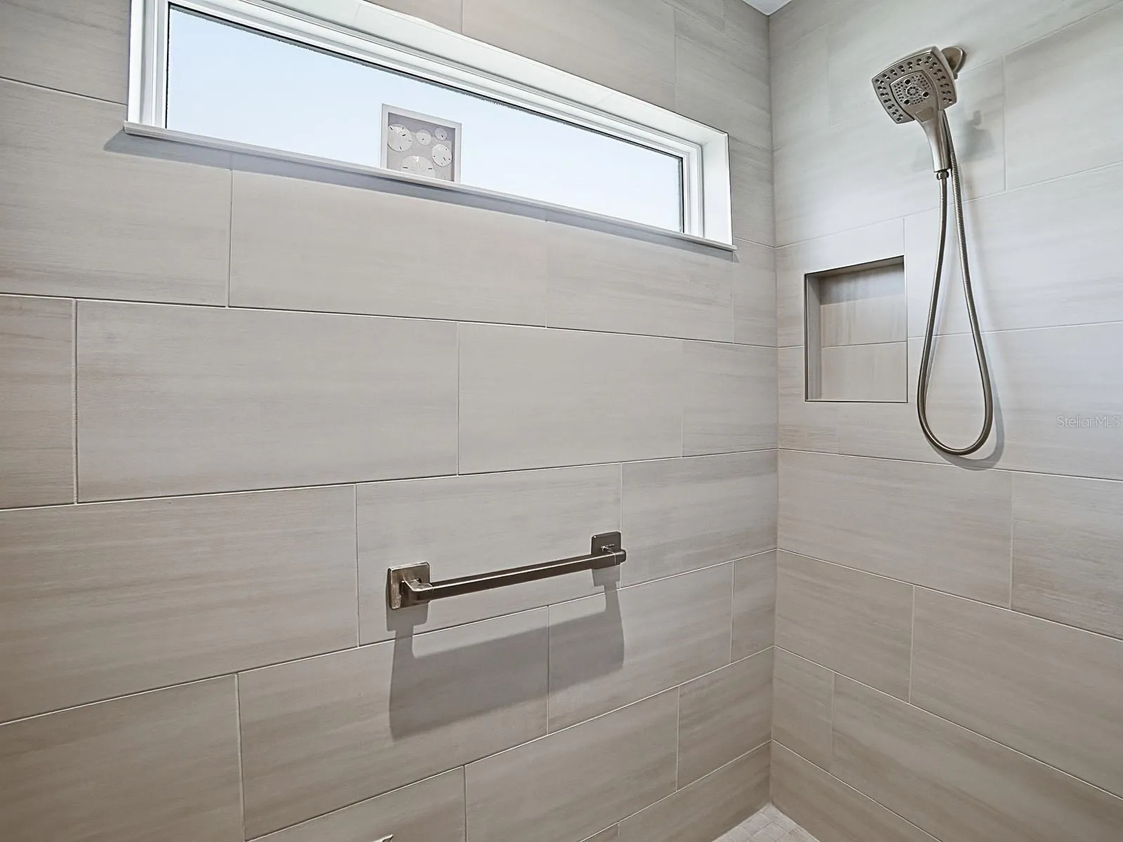 LOVELY TILED SHOWER WITH A WINDOW.