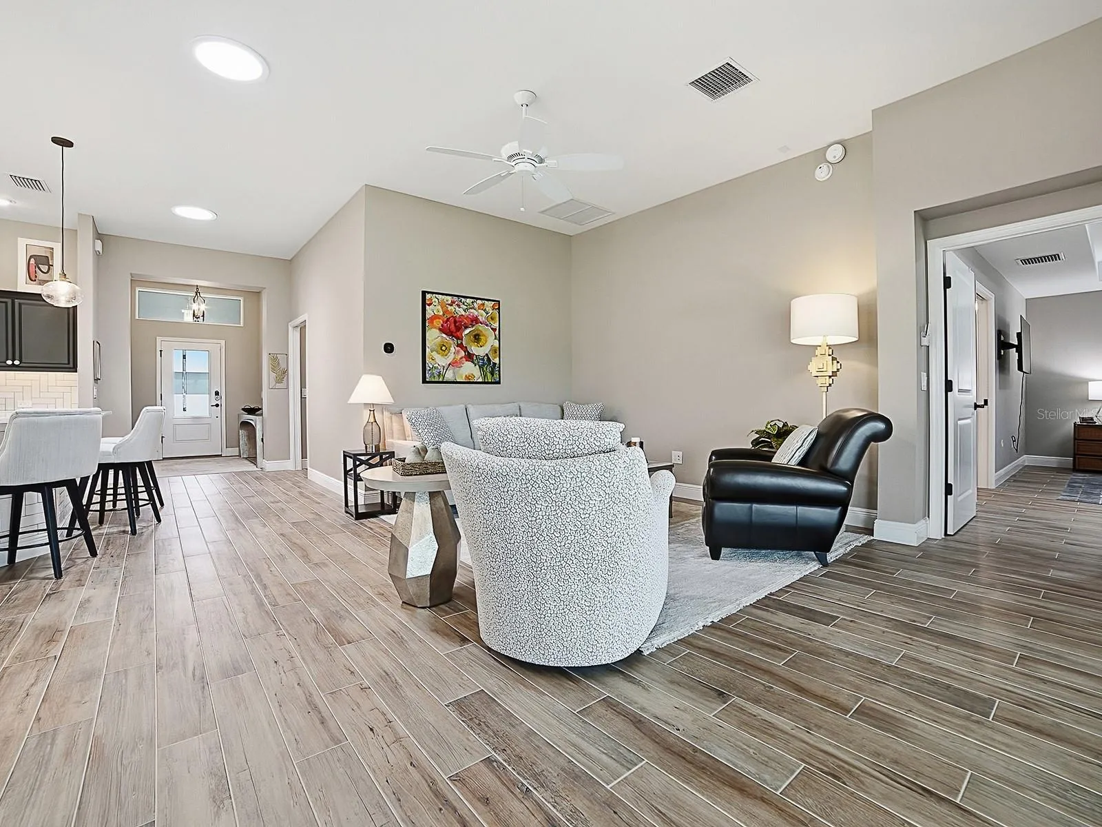OPEN FLOOR PLAN WITH SOLAR TUBES THROUGHOUT THE HOME FOR NATURAL LIGHTING.  THE POCKET DOOR TO THE RIGHT LEADS TO ANOTHER GUEST SUITE AND LAUNDRY.  THE KITCHEN IS TO THE LEFT.