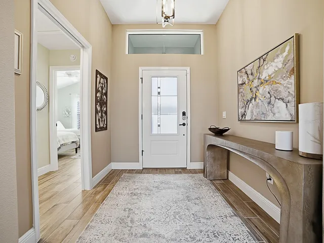 WOOD-LOOK PORCELAIN TILE FLOWS THROUGHOUT THE HOME! NICE LARGE FOYER WITH A POCKET DOOR THAT LEADS TO ONE OF THE GUEST SUITES.
