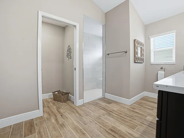 POCKET DOOR TO THE PRIVATE TOILET ROOM AND ROMAN WALK-IN SHOWER TO THE RIGHT.