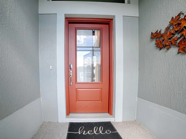 INVITING ENTRANCE WITH A DECORATIVE CONCRETE COATED ENTRANCE AND LEADED GLASS FRONT DOOR.