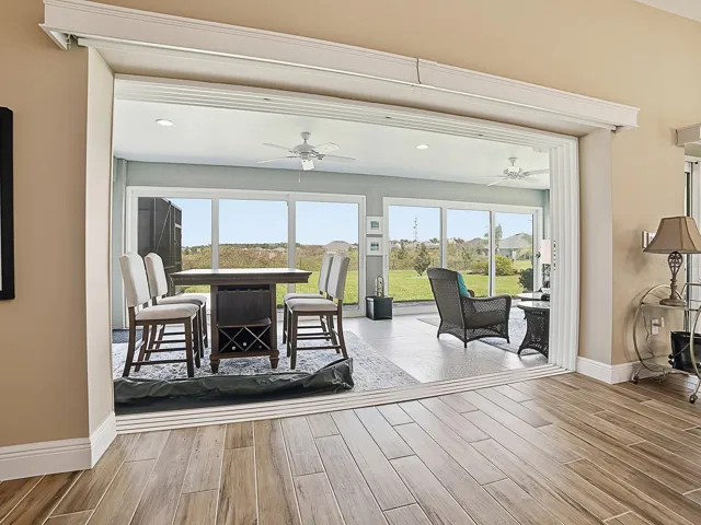 THE SLIDING GLASS DOORS HAVE REMOTE CONTROL PANEL TRACK BLINDS.