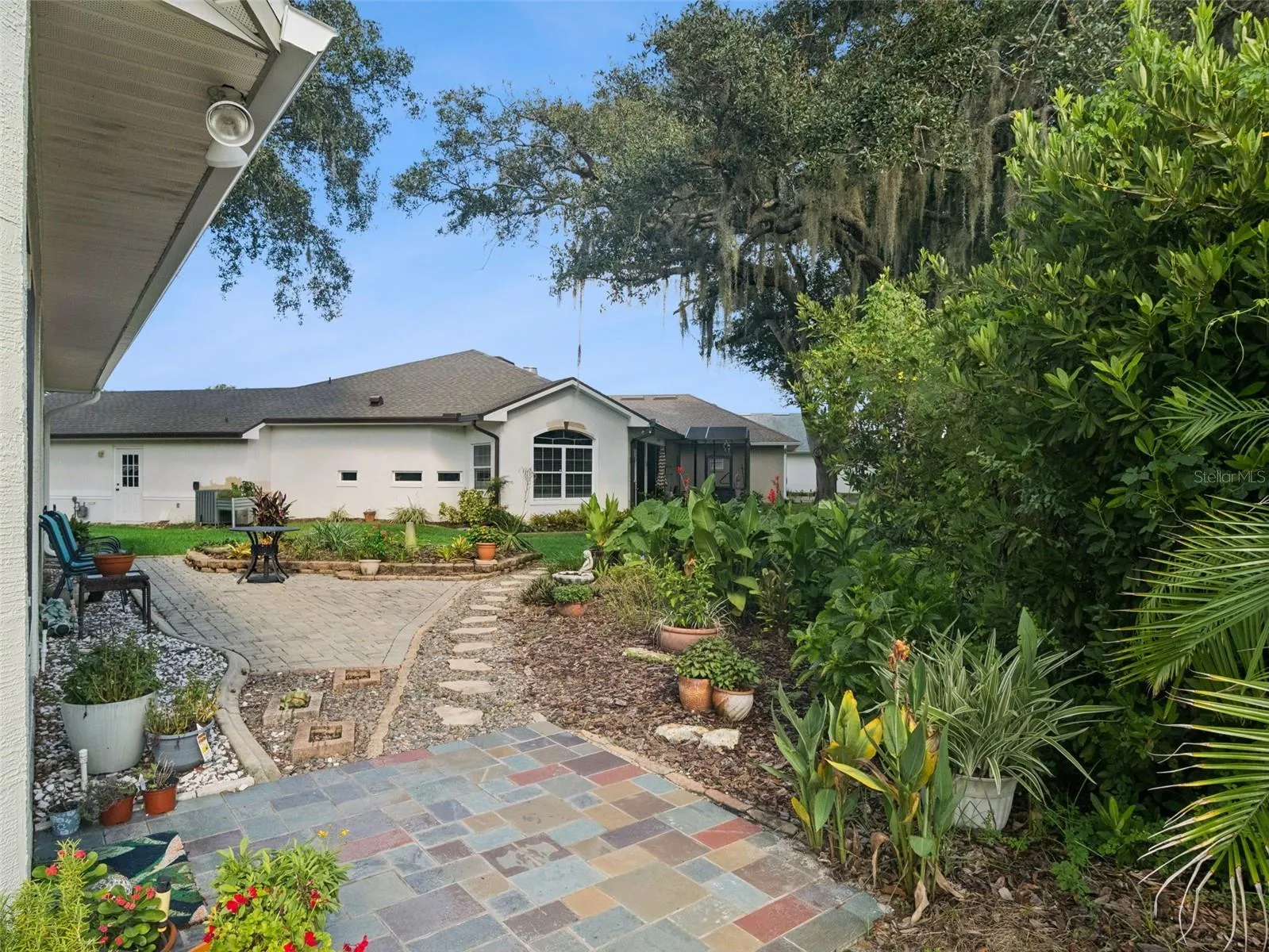 Welcome to this lush outdoor oasis comprised of easy-to-care-for Florida-friendly plantings.