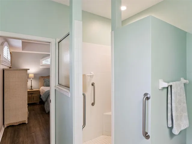 Primary en suite ~ the walk-in shower has a built-in bench and grab bars for safety.