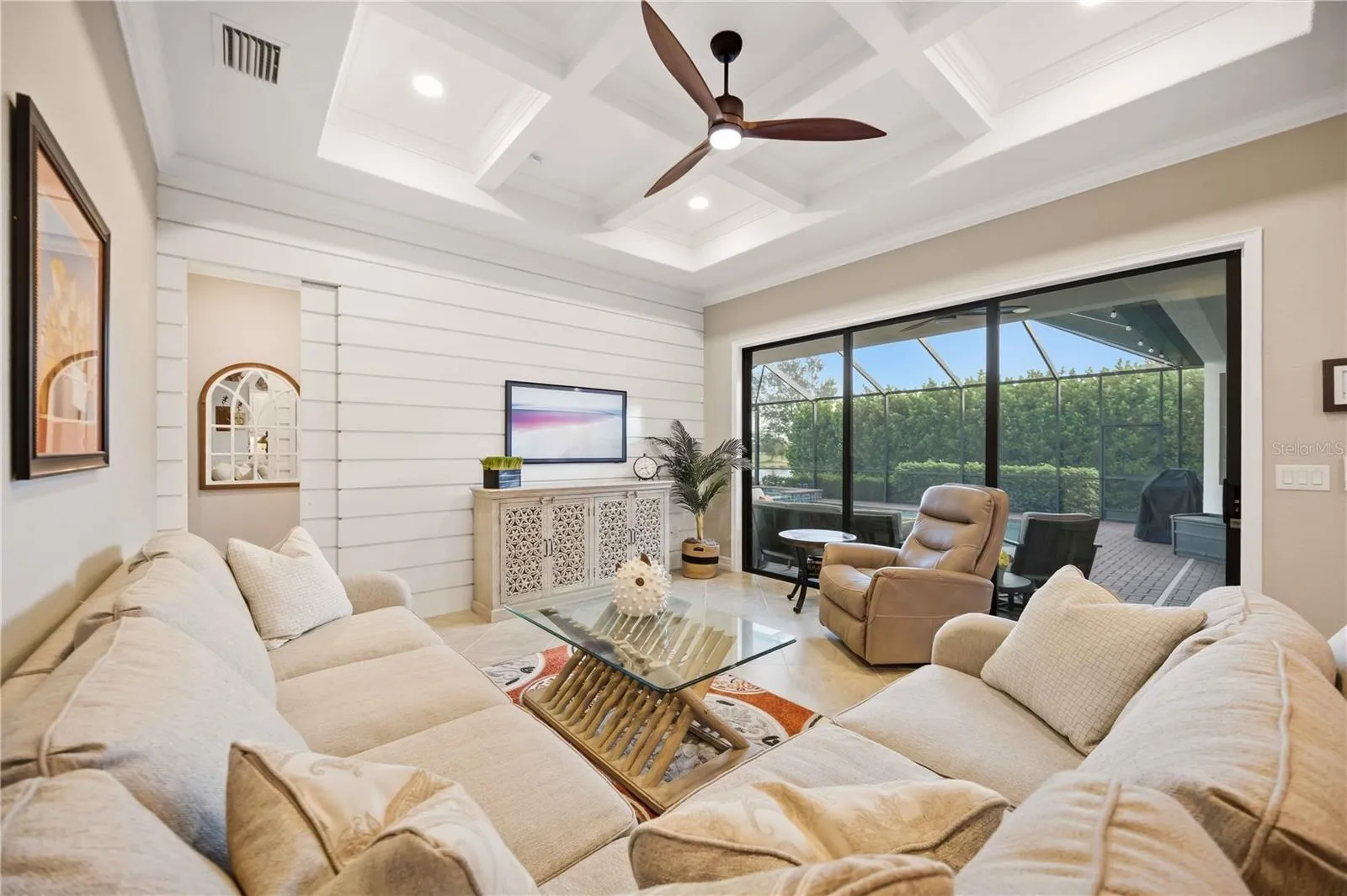 Fabulous great room with feature wall and architectural grid ceiling.  Sliders to the lanai