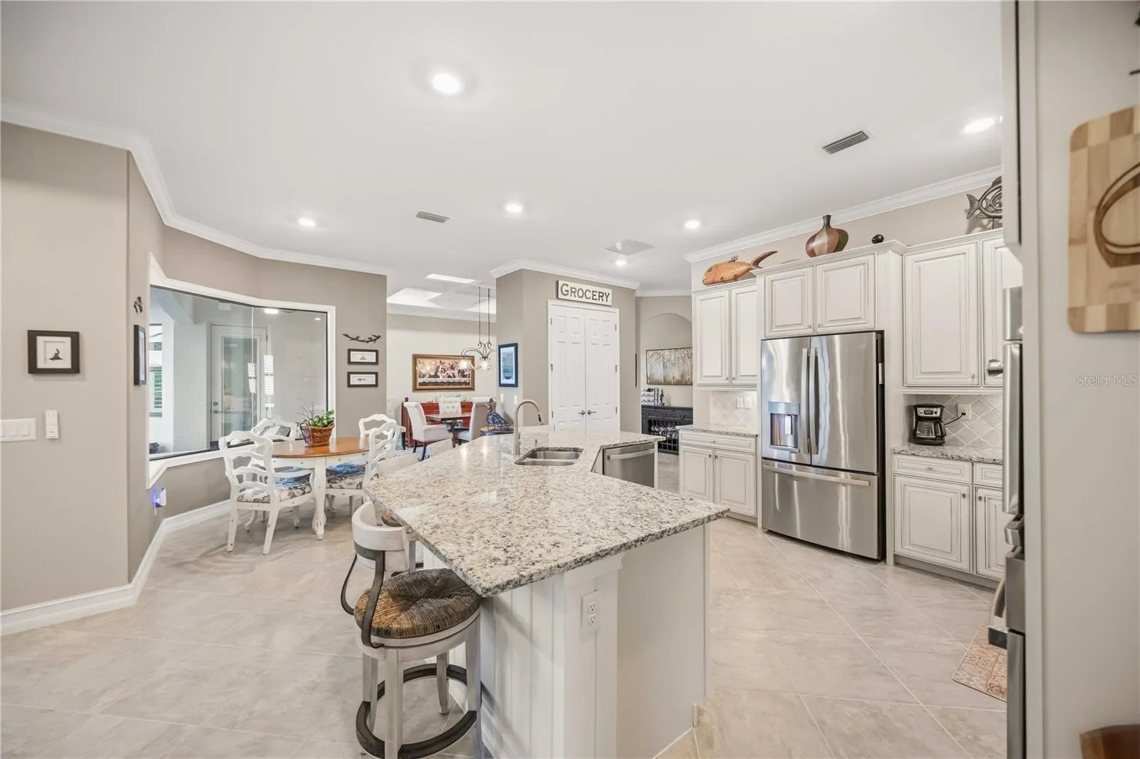Upscale Kitchen with double ovens, dishwasher, cooktop, plenty of counter space, and counter seating.