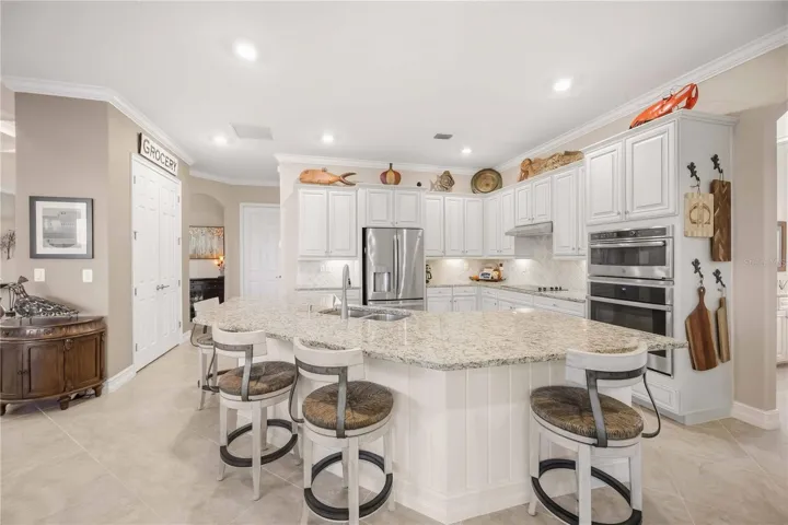 Upscale Kitchen with double ovens, dishwasher, cooktop, plenty of counter space, and dining on the counter.