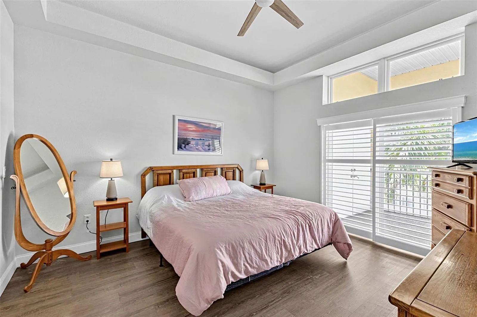 Primary bedroom with slider doors to the enclosed patio