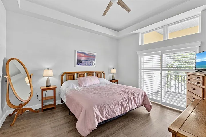 Primary bedroom with slider doors to the enclosed patio
