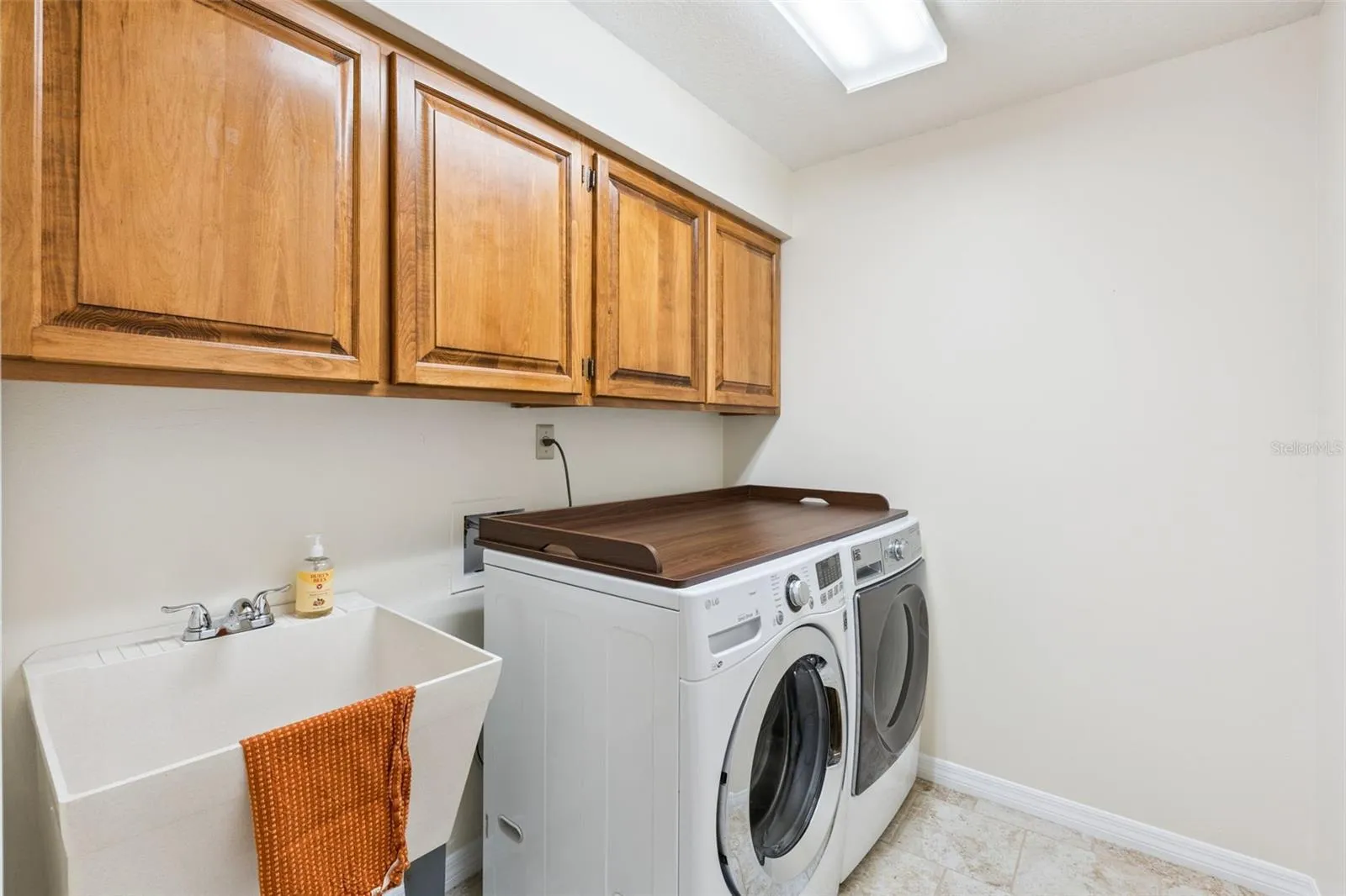 Laundry provides cabinetry as well as extra sink.