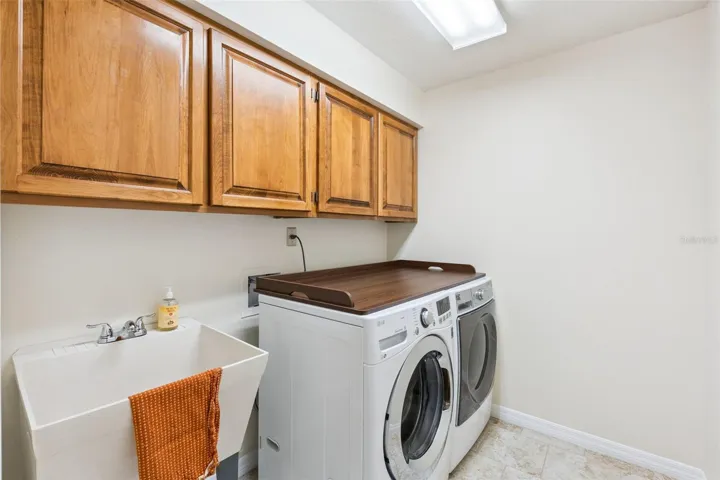 Laundry provides cabinetry as well as extra sink.