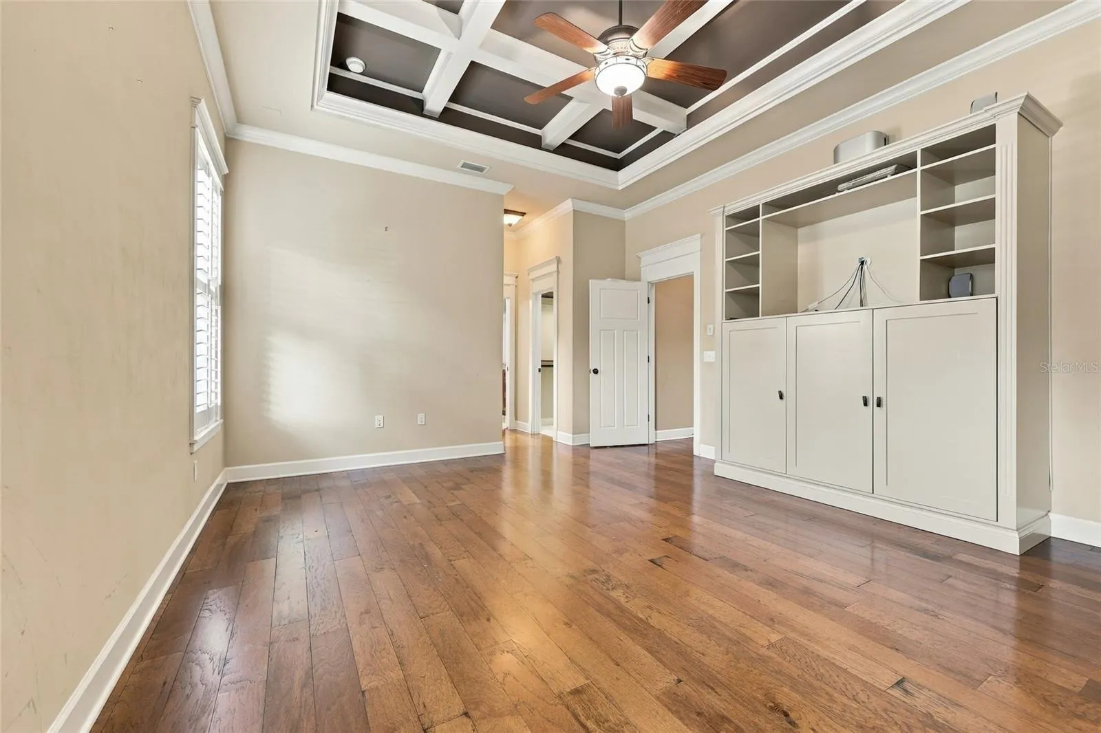 Primary Bedroom Suite with coffered ceiling and custom built-ins