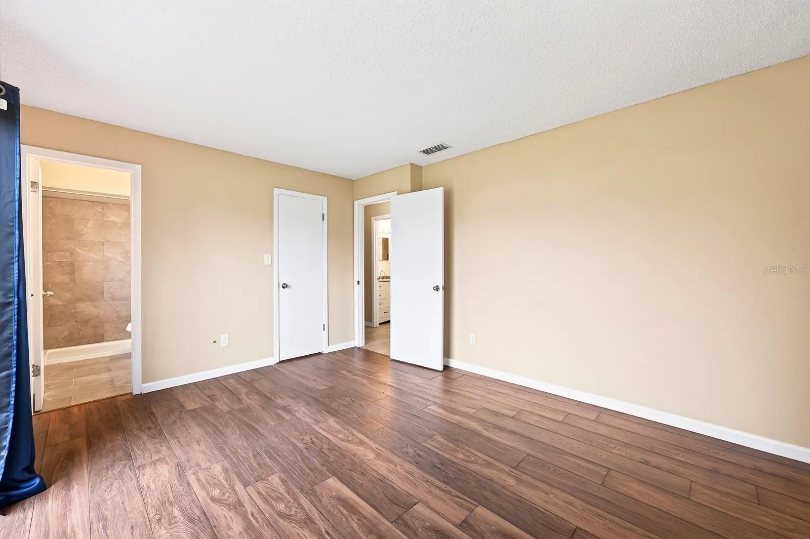 The spacious Primary Bedroom includes sliding glass doors that open directly to the backyard, bringing in plenty of NATURAL LIGHT and creating EASY ACCESS to the outdoor space.