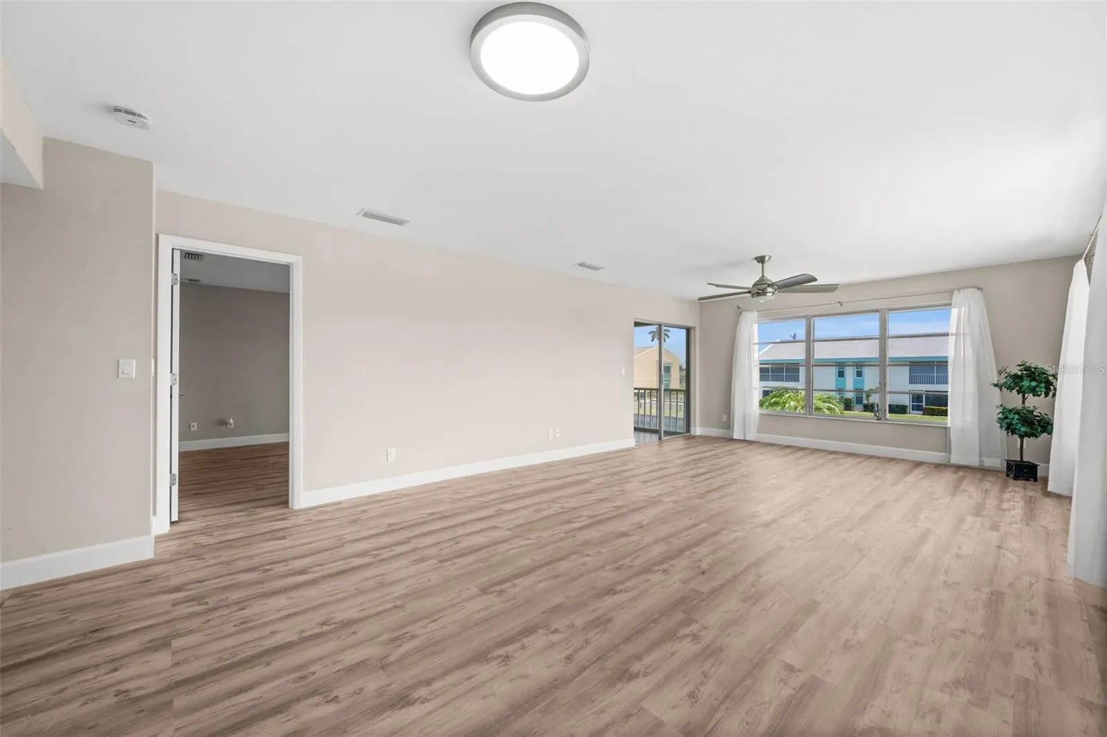 Living Room with door to the Primary Suite to the left, and access to the lanai