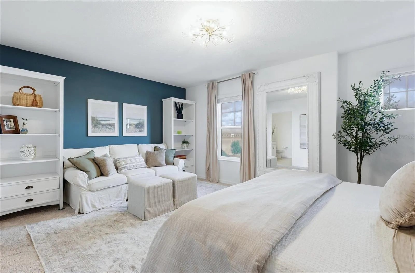 Primary bedroom with seating area and view of lake