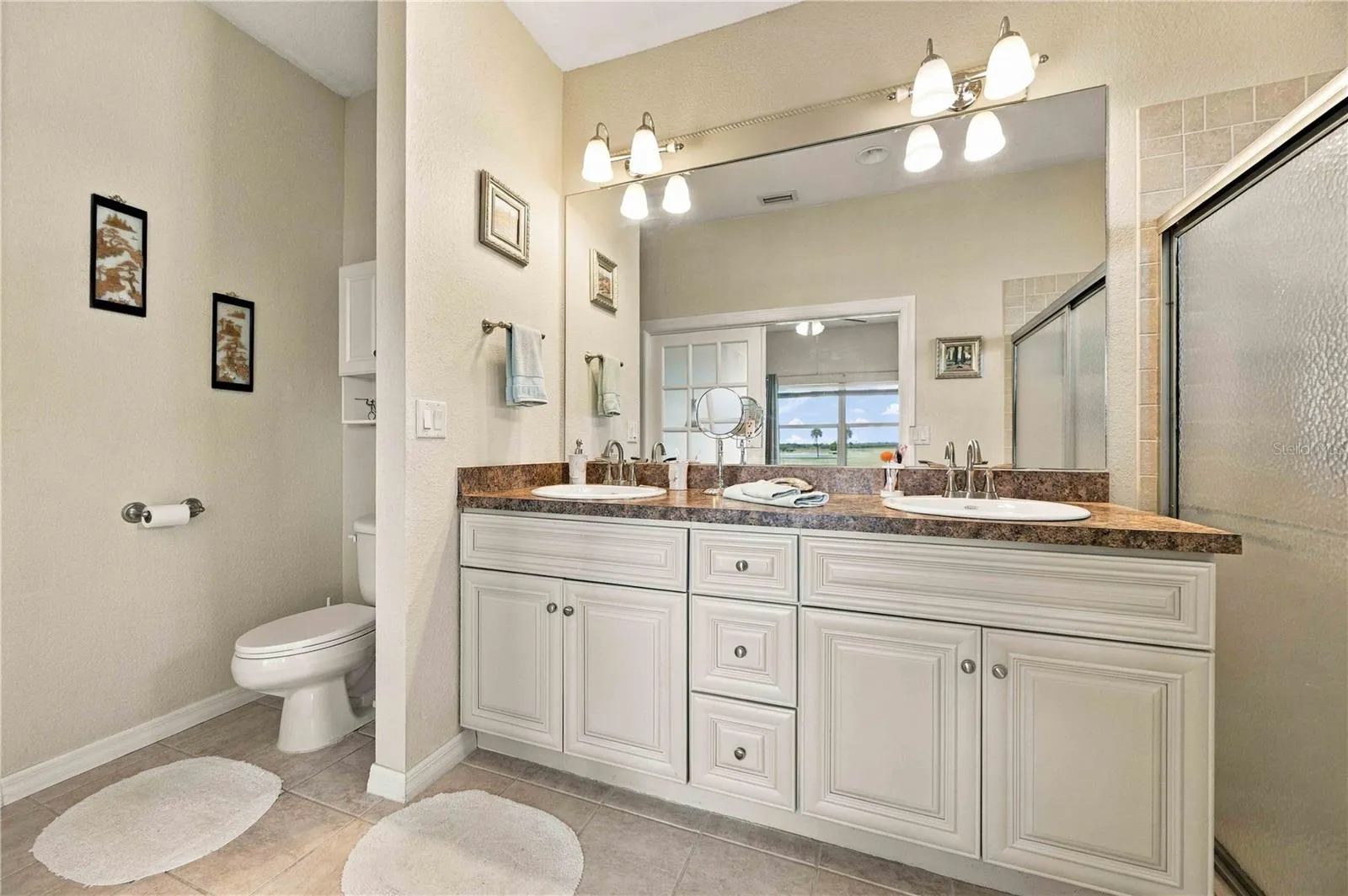 Primary bathroom features a vanity with double sinks and a spacious walk-in shower.
