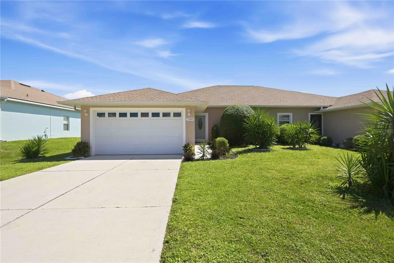 This property features a mature, well-maintained landscape complemented by a lush, green lawn.