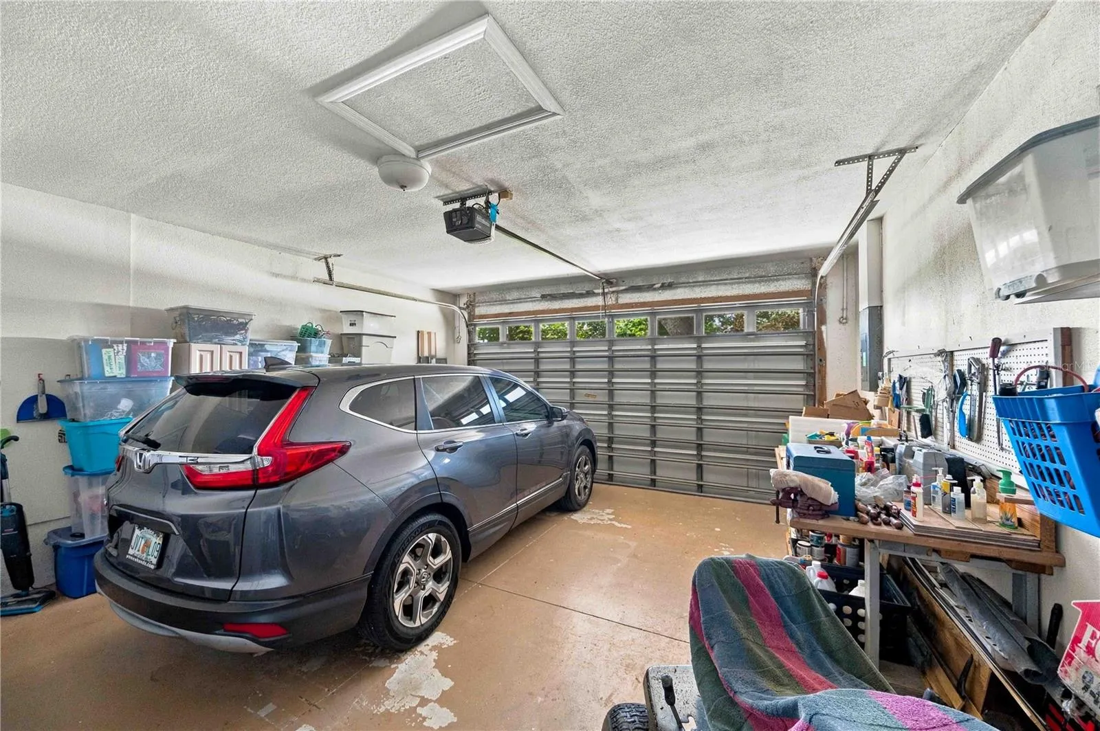 This spacious garage includes ample room for a workbench and storage, and features a convenient automatic door opener.