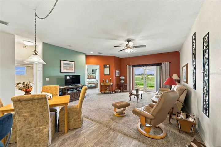 open living area with ceiling fan overlooking the 16 hole with lake beyond