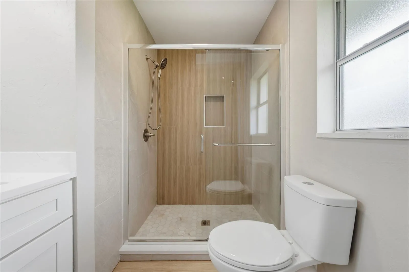 Tiled walk-in shower with frameless glass door
