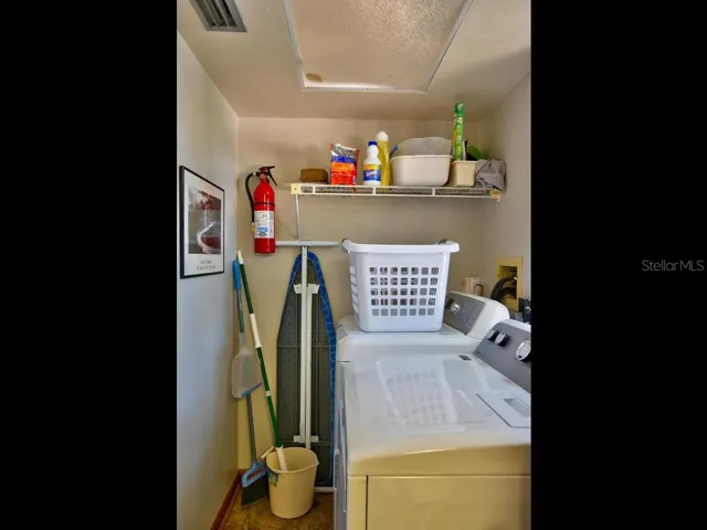Laundry room has full size washer dryer off half bathroom