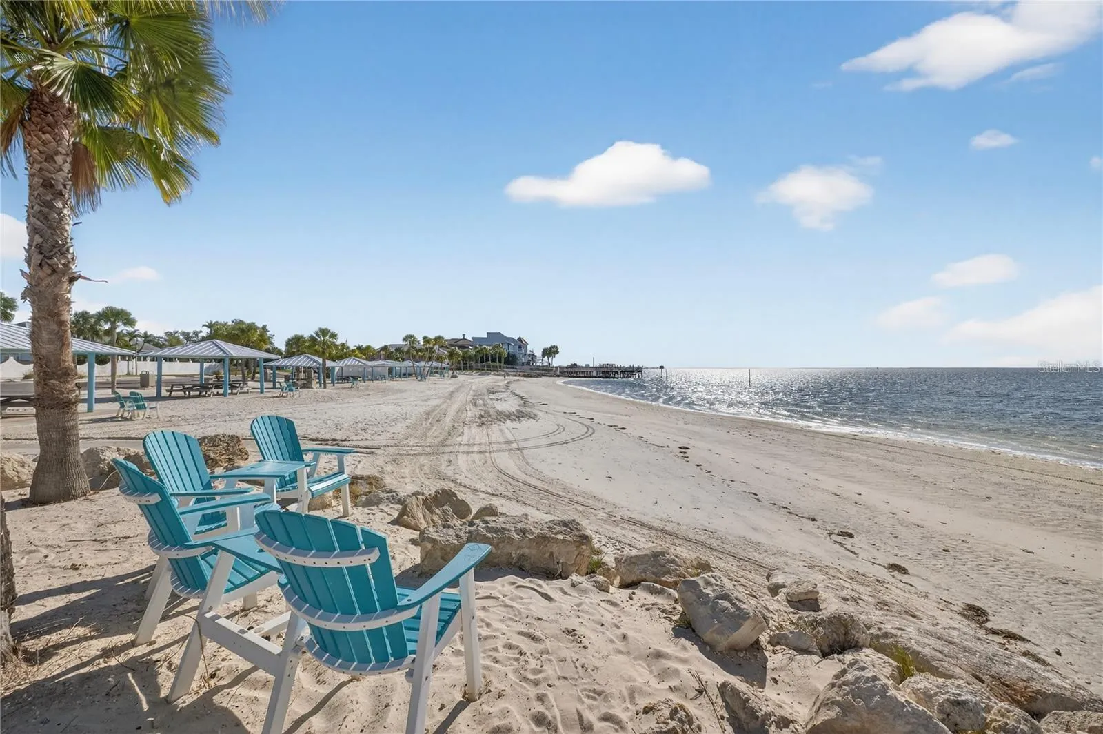 Beach chair and palms on sandy shores