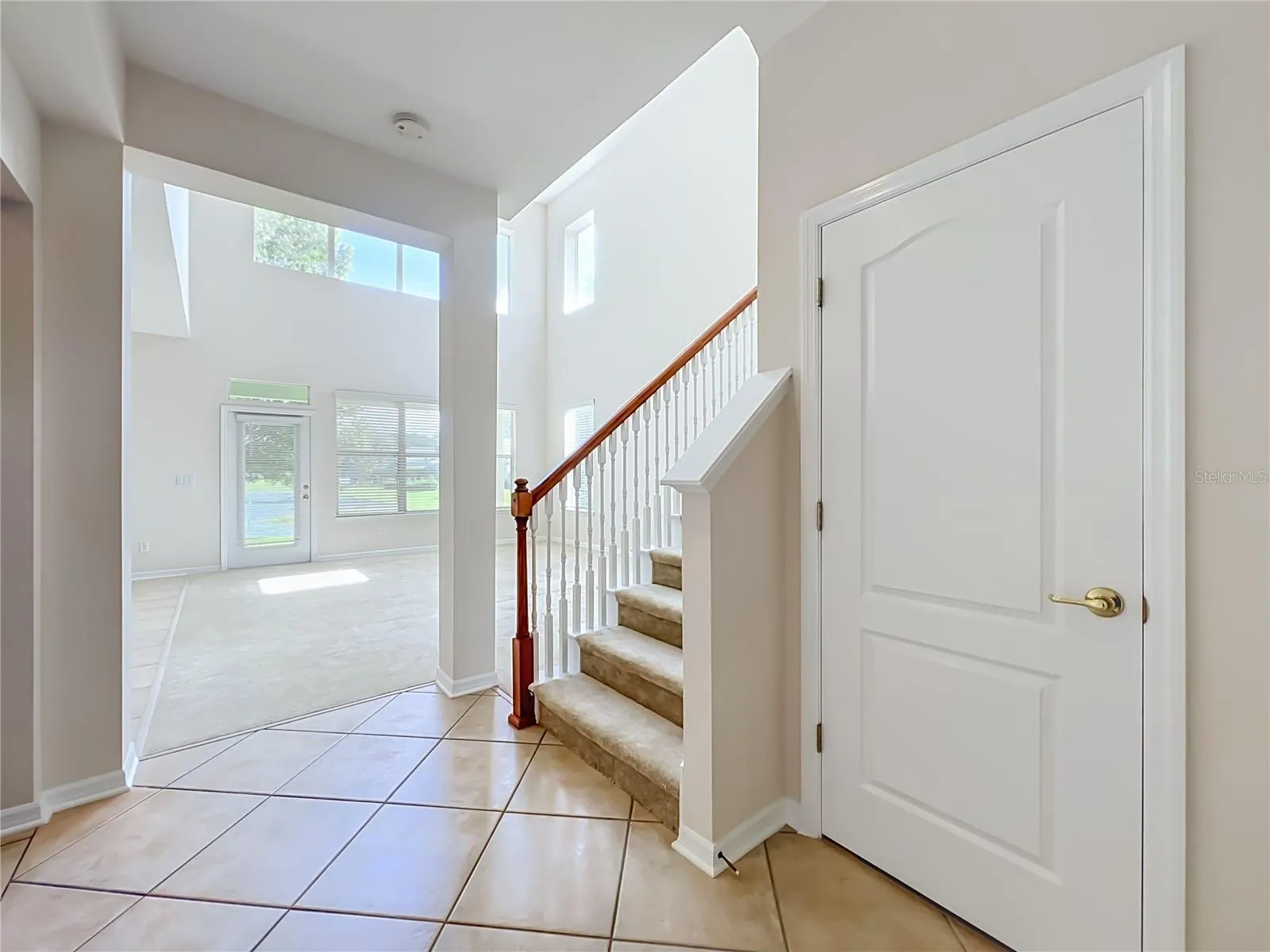 Hall closet and carpeted stairway in the center of the home