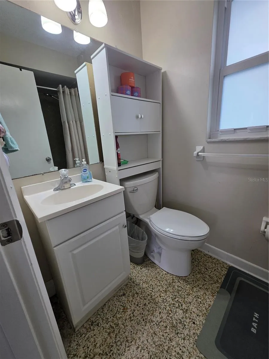 sink, overhead storage and full shower in this room