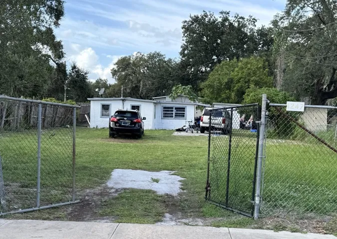1247 19th Street — wide exterior view, the third contiguous preproperty - showing the fenced lot and setback from the street