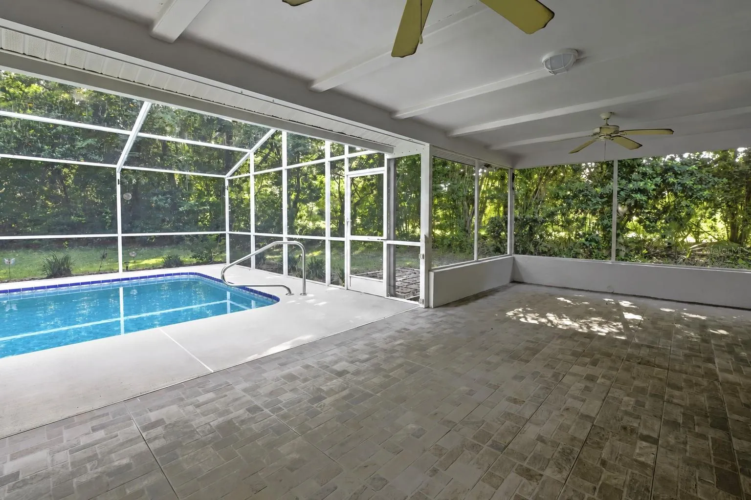 Covered lanai overlooking the screen-enclosed pool