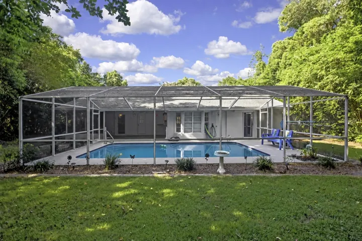 Rear view of the screen-enclosed pool and home