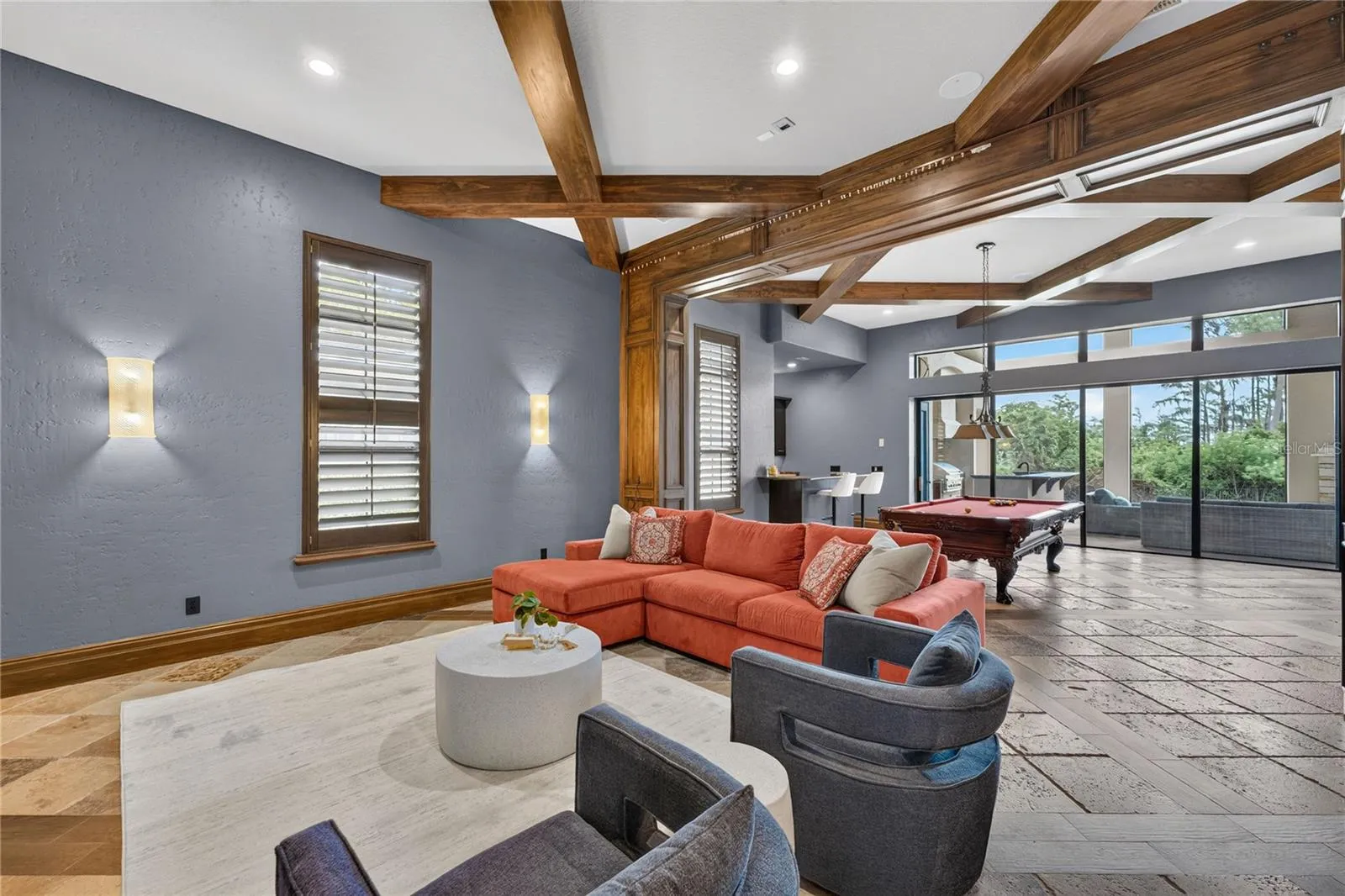 Game/Media room located off the family room. Beyond the pool table a wall of sliders pocket to open the screened lanai to this area for seamless outdoor/indoor entertaining and living.