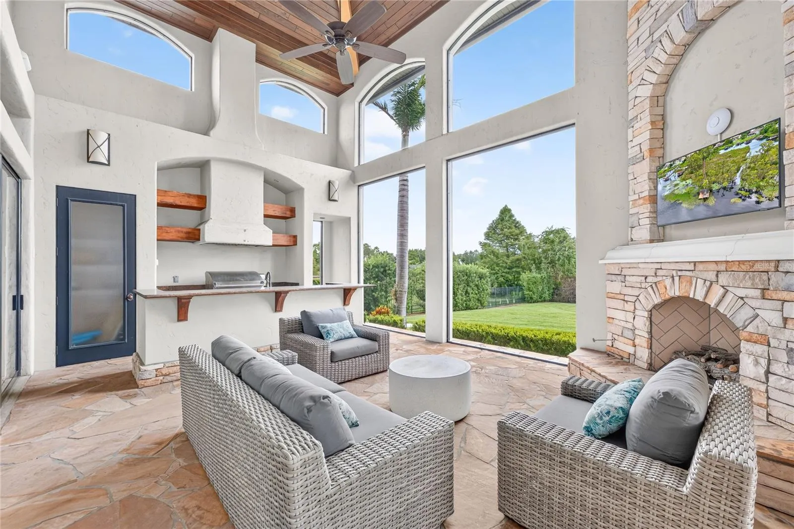 This area of the covered lanai is screened with a remote controlled screen to the covered outdoor dining area and pool. Full summer kitchen with bar. A natural GAS outdoor fireplace anchors evenings that stretch long past sunset.