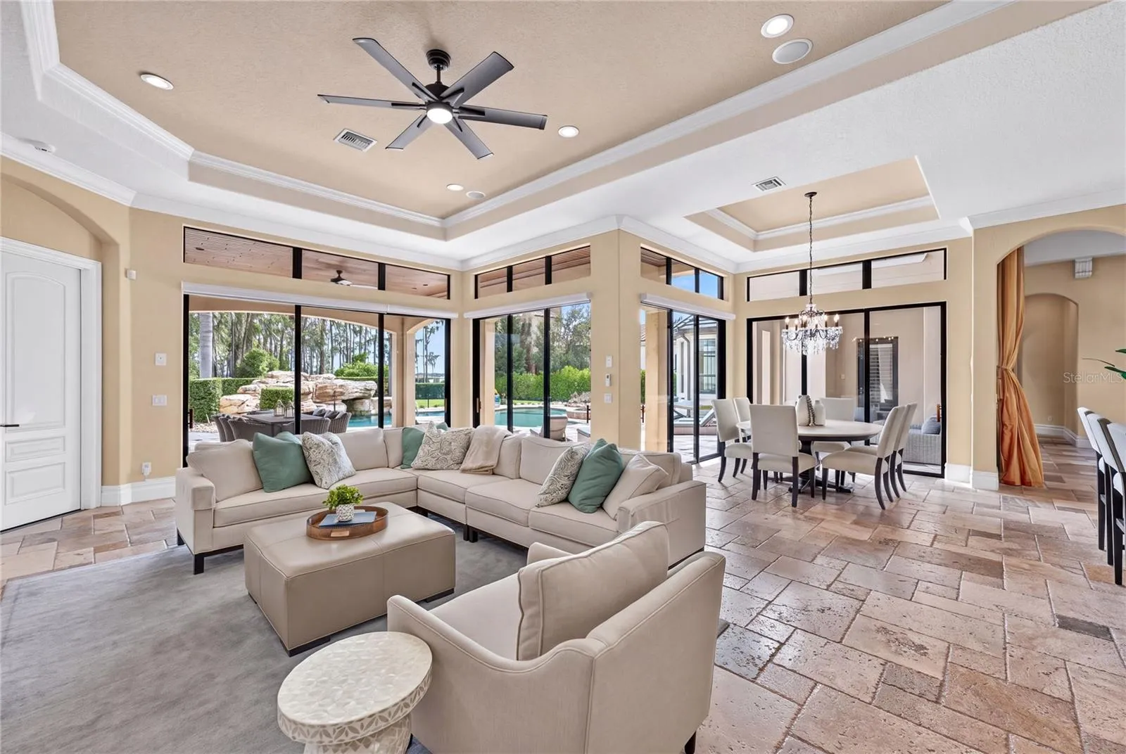 The outdoor dining, pool and lake beyond can be seen from the casual living.