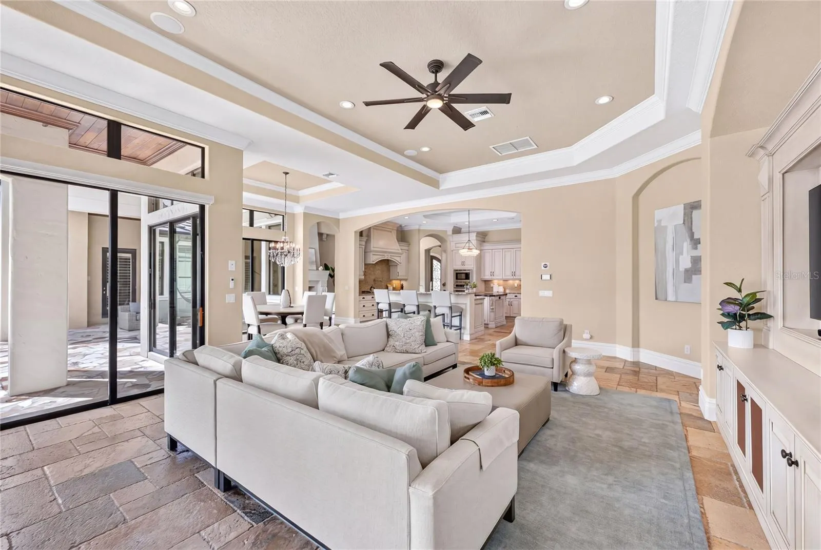 Casual family room with built-in TV wall (all televisions CONVEY with the house). Notice the speakers in the ceiling. The WHOLE house has a newly added SMART HEOS system- throughout the inside of the home as well as outside patio - with each room wirelessly controlled separately.
