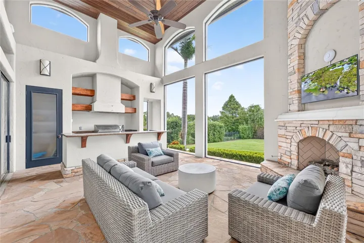This area of the covered lanai is screened with a remote controlled screen to the covered outdoor dining area and pool. Full summer kitchen with bar. A natural GAS outdoor fireplace anchors evenings that stretch long past sunset.