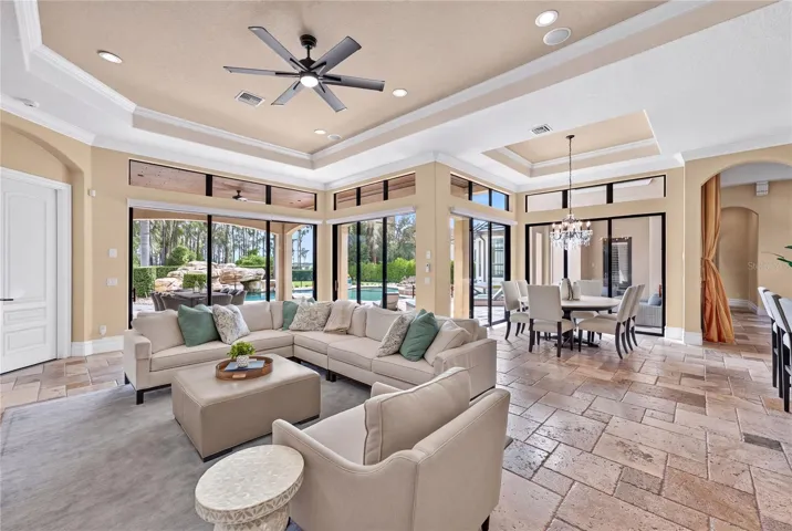 The outdoor dining, pool and lake beyond can be seen from the casual living.