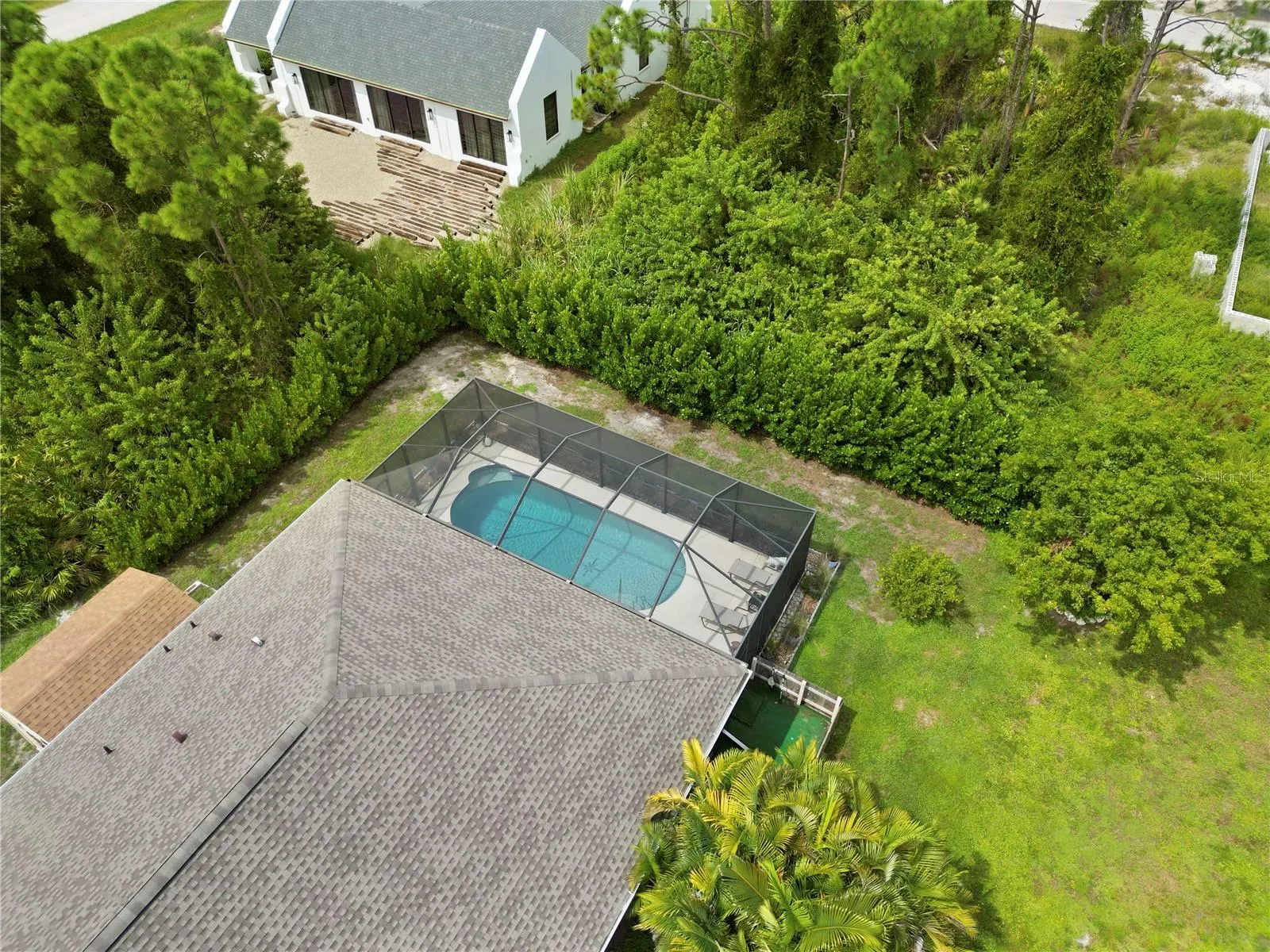Drone view of home, currently vacant lot behind the property.