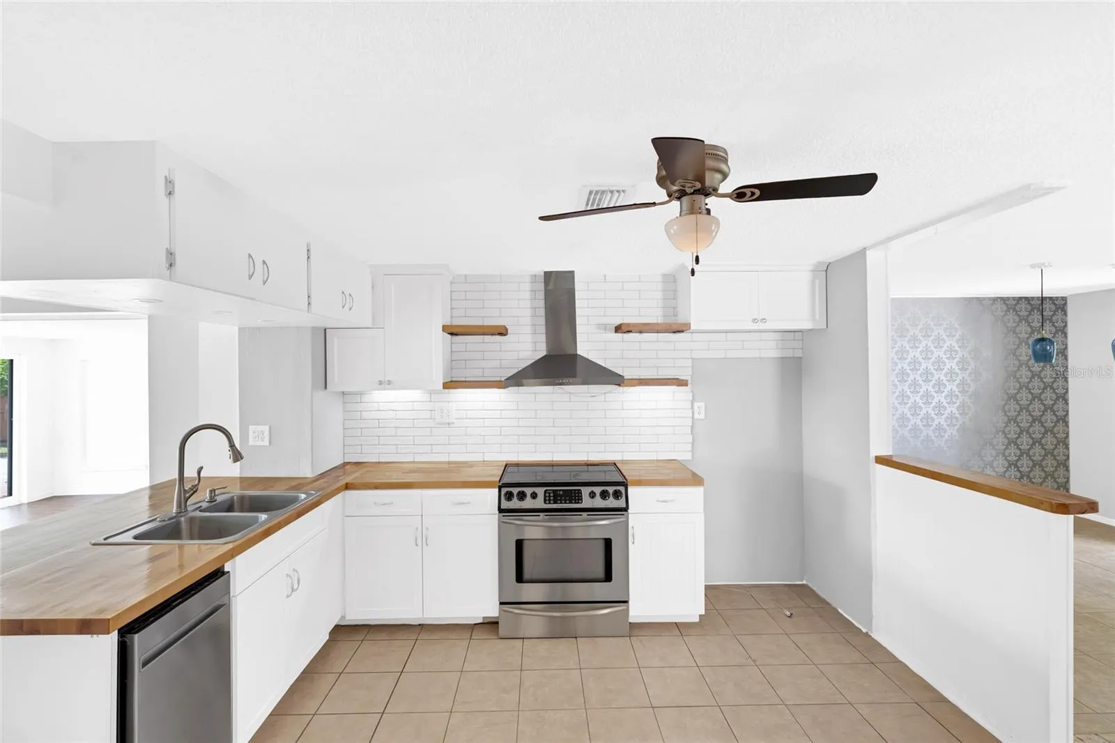 A stainless steel range and vent hood anchor the kitchen, with generous counter space for cooking and entertaining.
