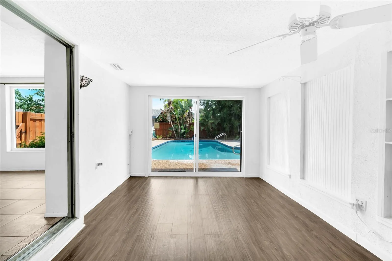 Flexible bonus room overlooking the backyard pool with direct access to the rear living area.