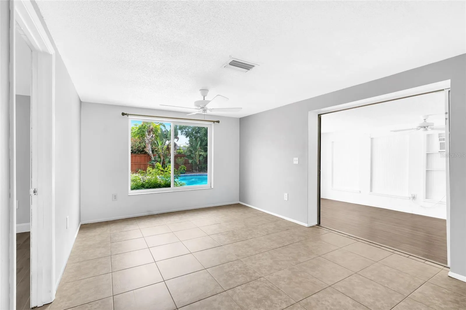 The family room offers a true second living space with a large picture window overlooking the private pool and tropical backyard.